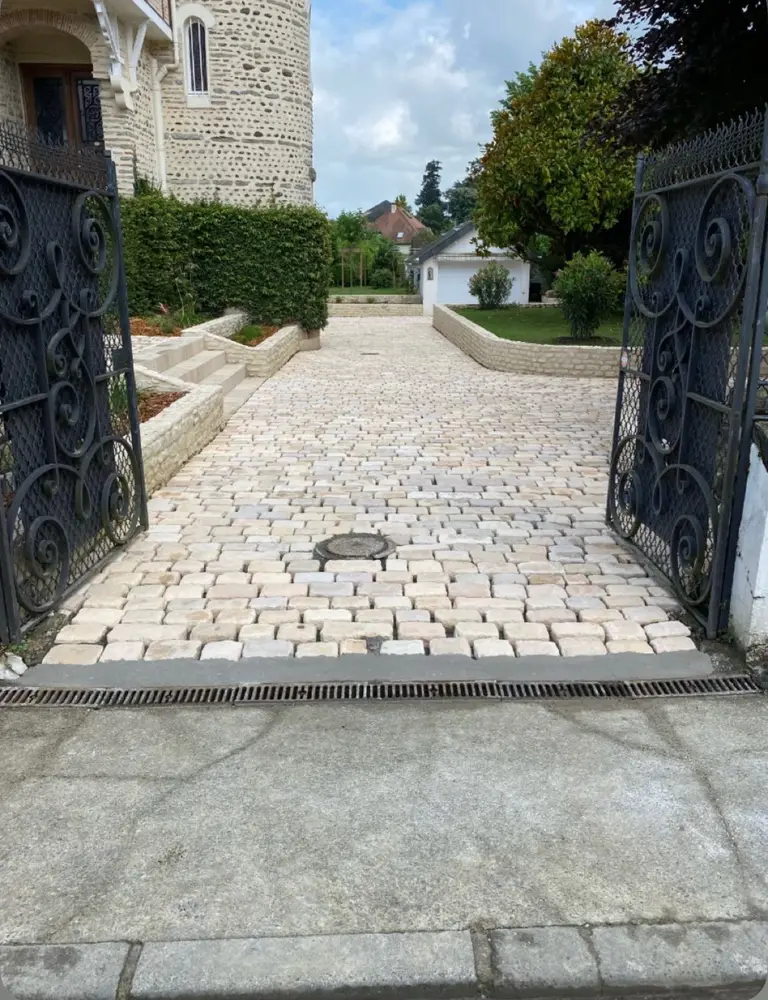 Allée d'entrée en pavés posée par Andy Service, derrière un portail en fer forgé